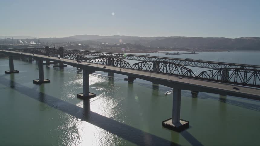 Traffic moves across two bridges connecting two small communities