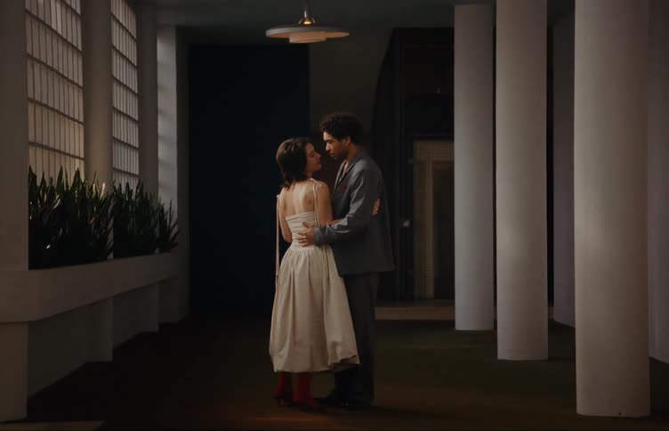 A couple in formal clothes are dancing slowly and looking at each other romantically