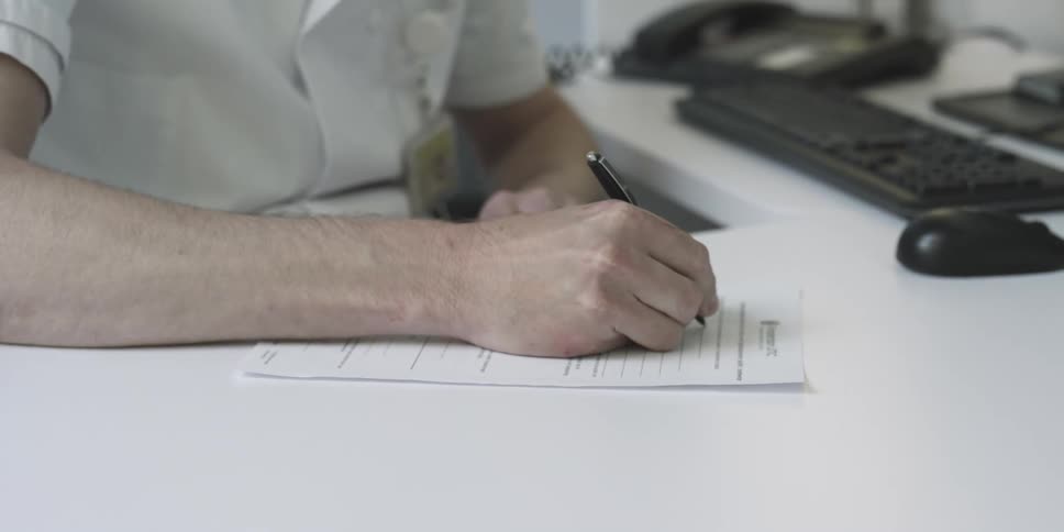 A nurse fills out a form in an office