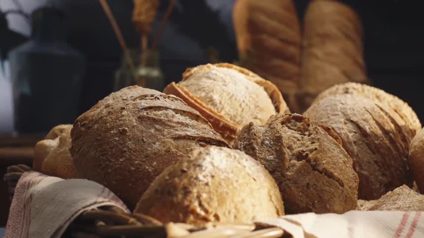 A man sets a basket of bread on a table