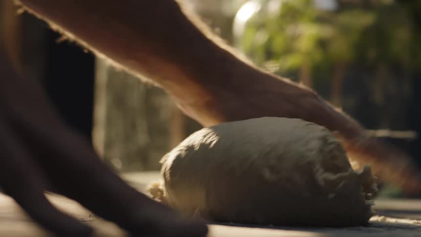 A man kneads dough on a table