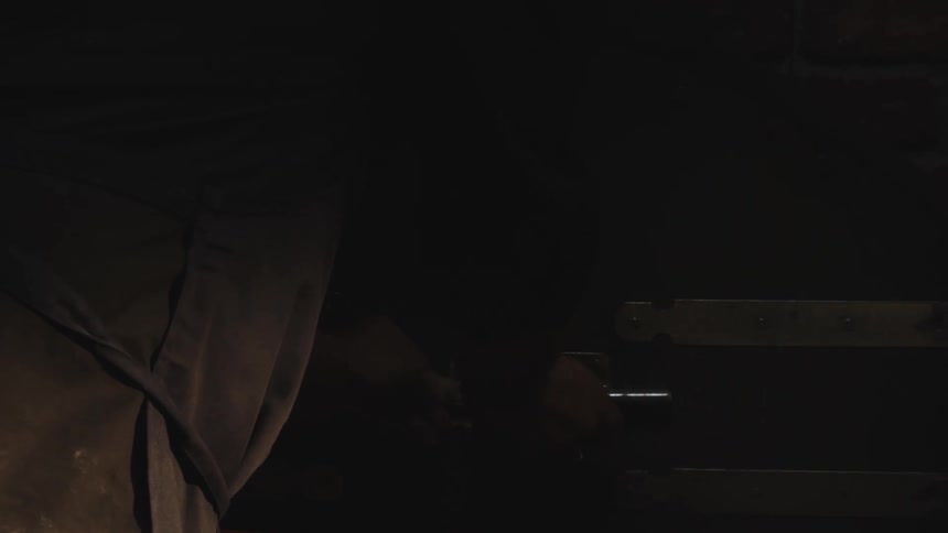 A mans hands closing the door of a furnace with bread dough being baked