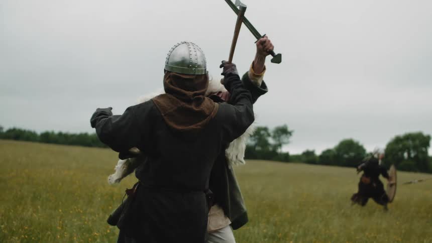 People engage in combat on a grass field