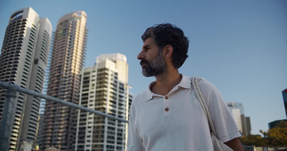 A man looks around as he walks through a city downtown area
