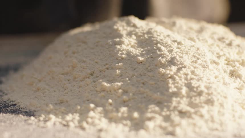 A hand kneading dough on a surface