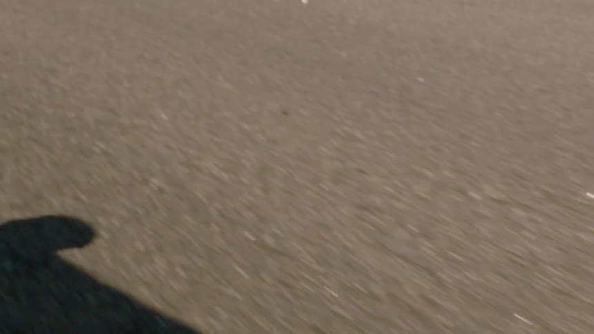 Closeup of the wheels of a skateboard with a person riding and doing a trick