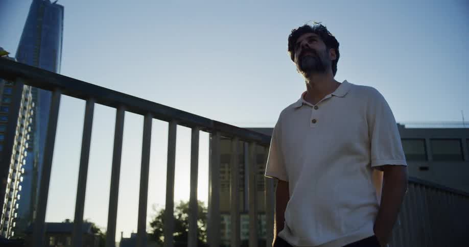 Man walking down a city street with a modern skyscraper around him
