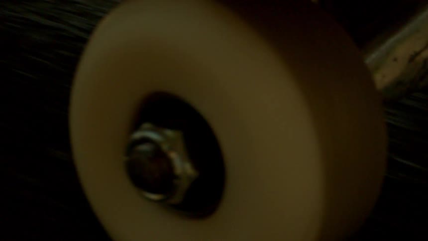 Close up of the wheels of a skateboard spinning on asphalt