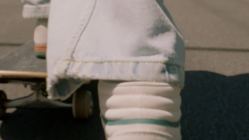 A person riding a skateboard uses their foot to move faster