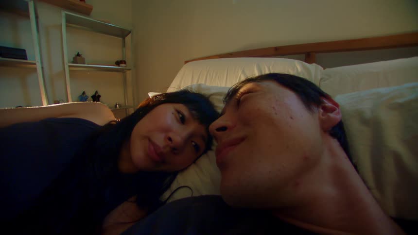 Young couple lying in bed and looking at each other romantically