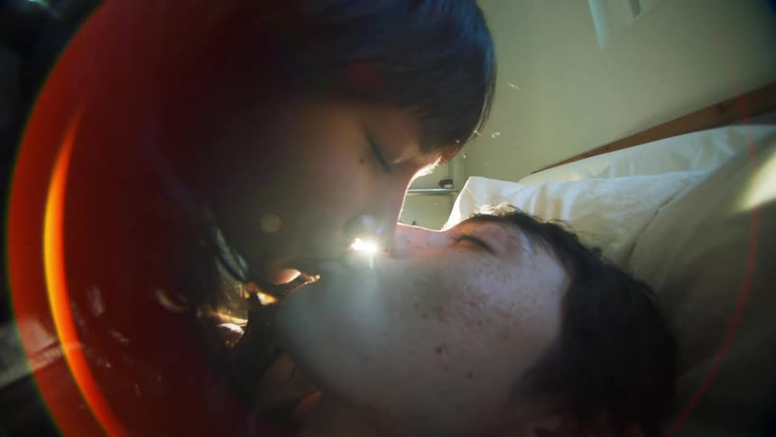 Portrait of a loving couple kissing while lying in bed