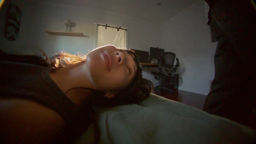 Young woman laying in bed turns to see her partner at morning