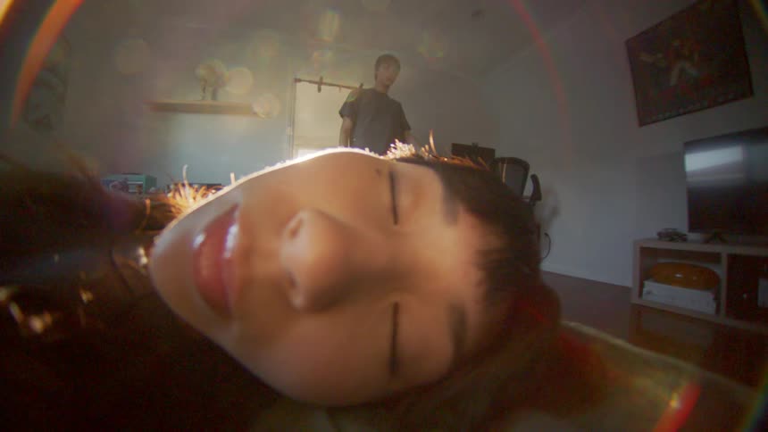 Portrait of a young woman sleeping and her boyfriend walking in the background