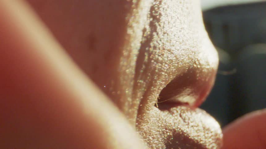 Close up of the cheek and mouth of a freckled person