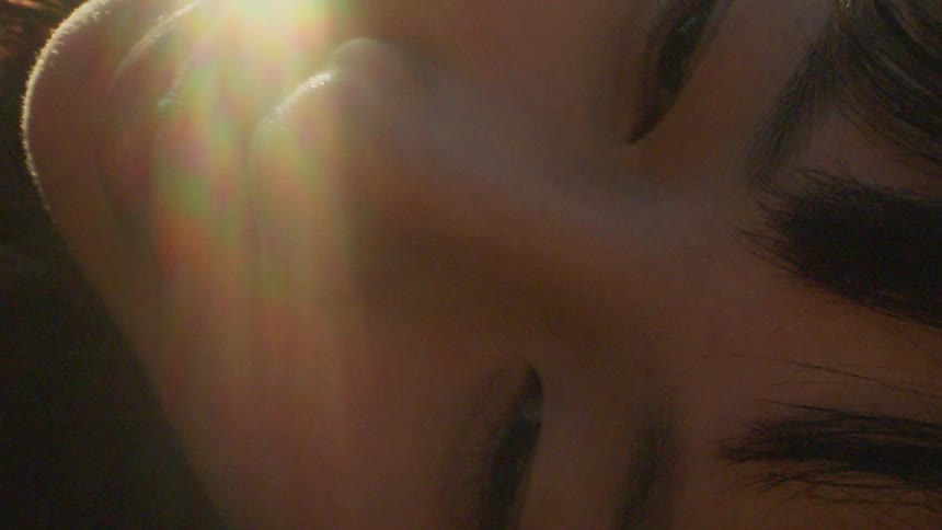 Close up of the face of a young woman under sunlight