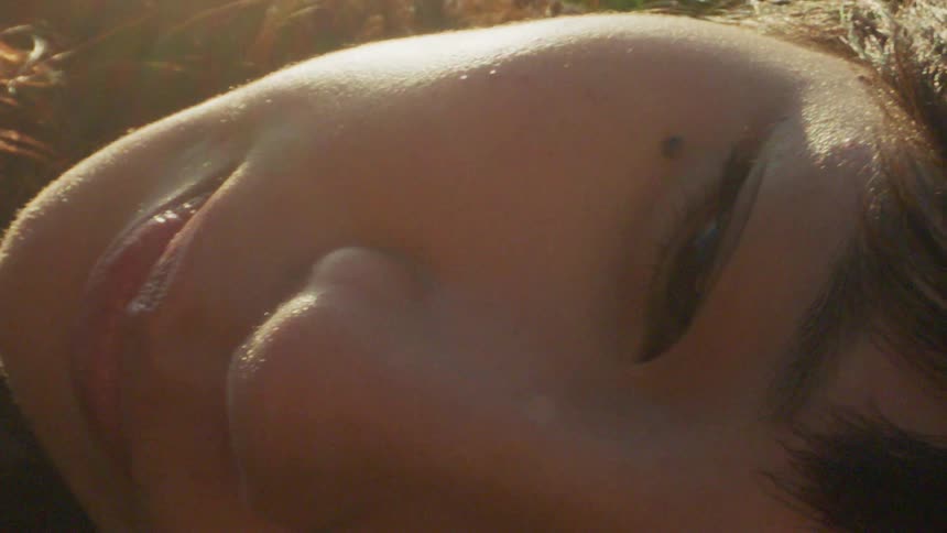 A woman lying down near another person outdoors