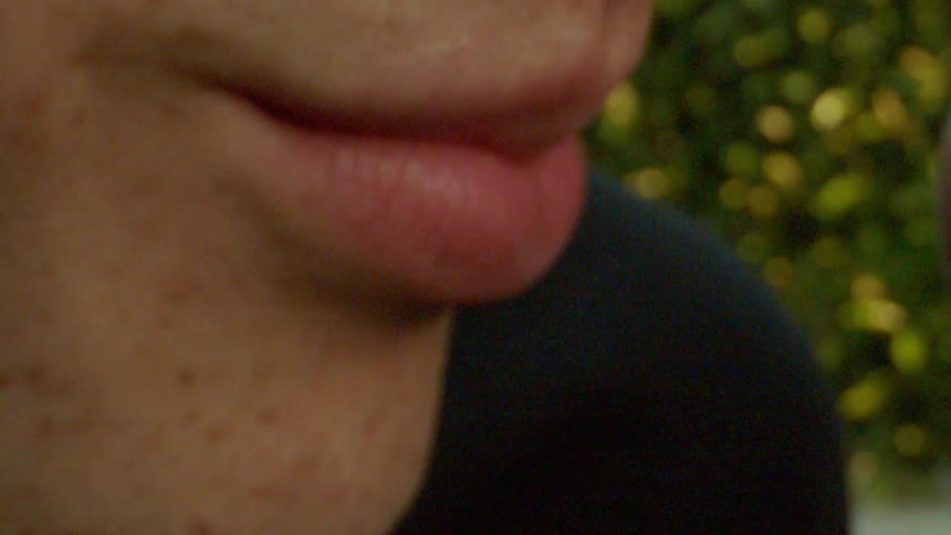 A man and a woman share a kiss outdoors