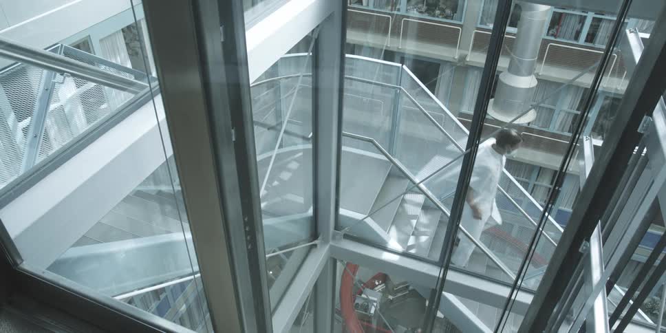 Man wearing a face mask walks down outdoor building staircase