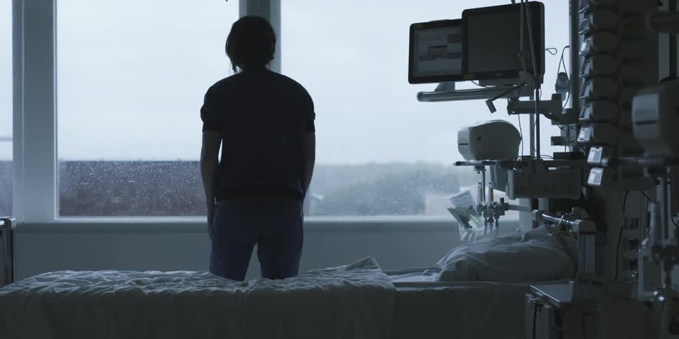 A woman gets up from a hospital bed and walks off
