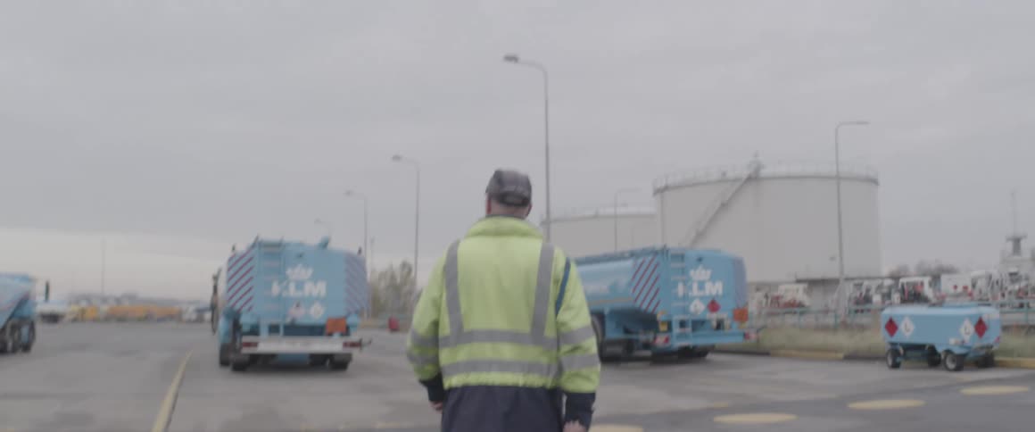 An employee of a refinery walks towards trucks