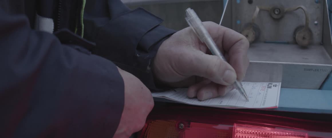 A man writes something on a piece of paper