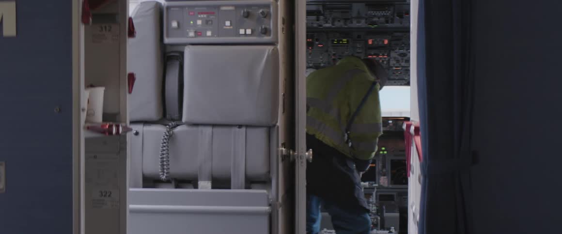 Working man in a signal shirt entering the cabin of an airplane