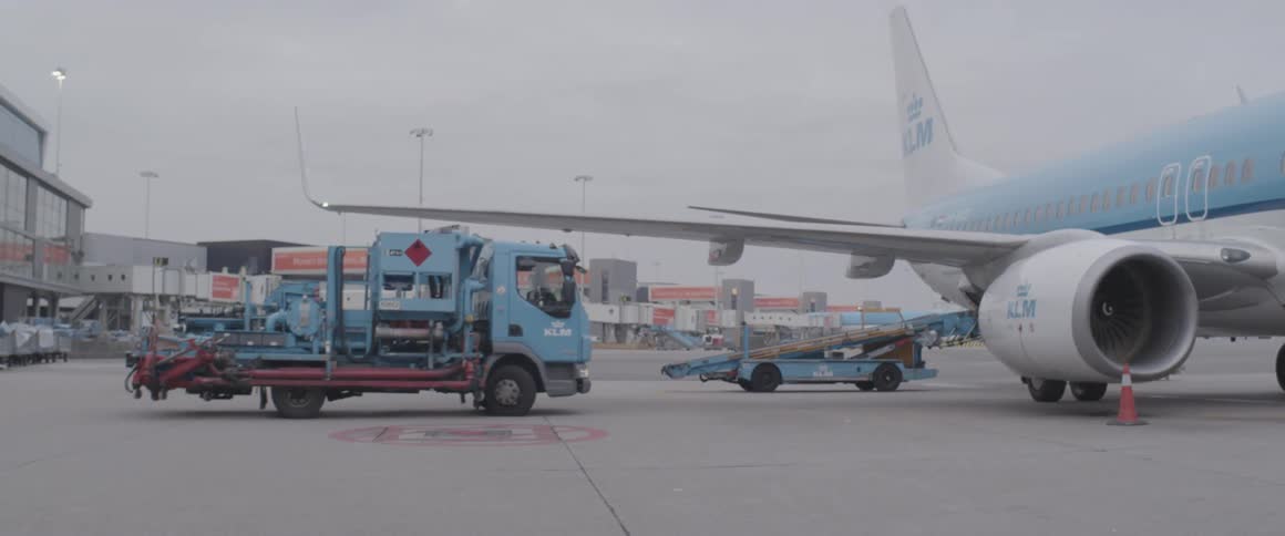 A truck approaches an airplane at an airport terminal
