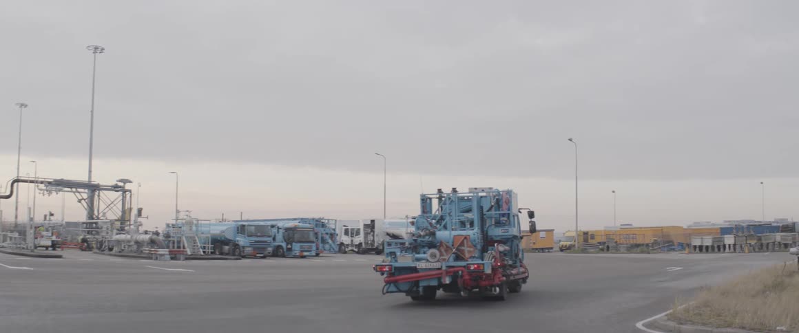 Blue truck equipped with cylinders and machinery traveling through an airport