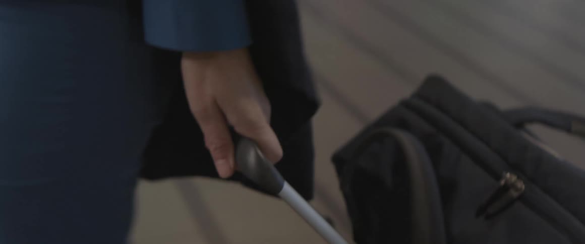 Womans hand carrying her suitcase through the airport