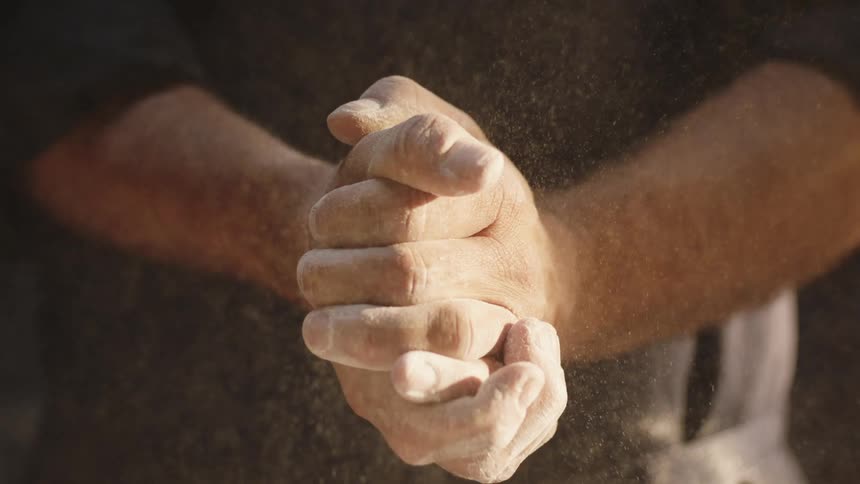 A man with flour on his hands claps them together