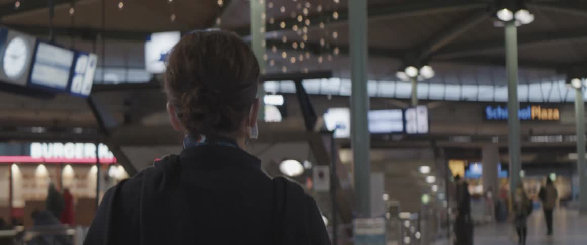 Back view of a woman walking inside an airport