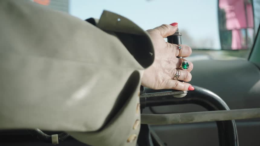 A womans hand pushes a lever on a machine