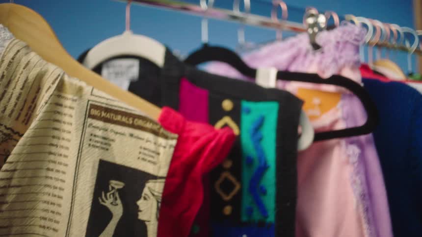 A clothes rack with colorful dresses moving after being touched