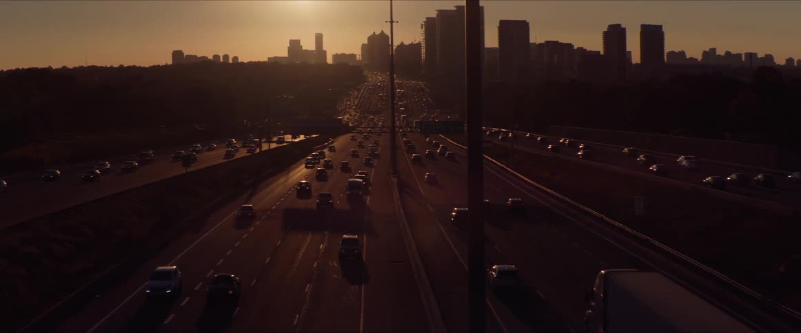 Multiple lanes of traffic driving into and out of a city core