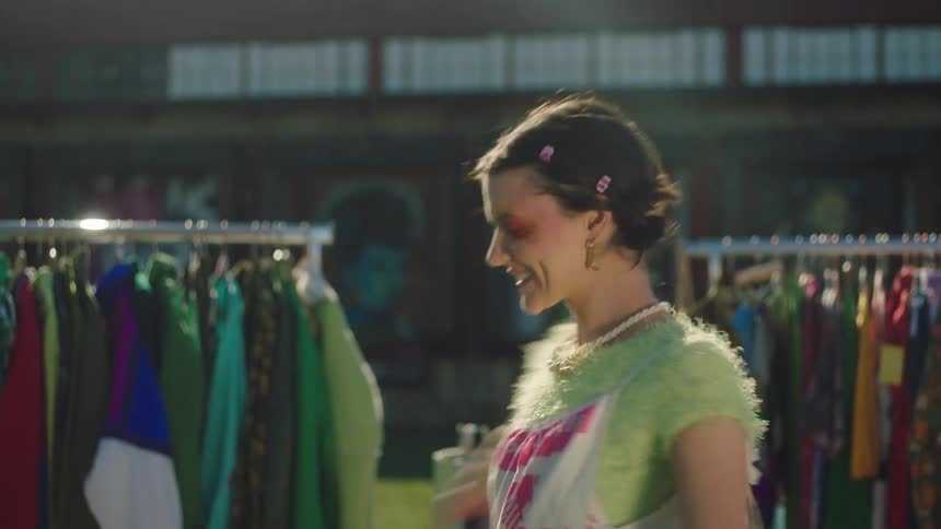 A young woman wearing wacky clothing outside a retail establishment