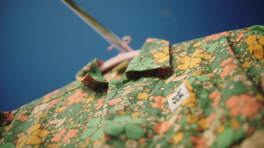 Closeup of a shortsleeved floral shirt on a hanger