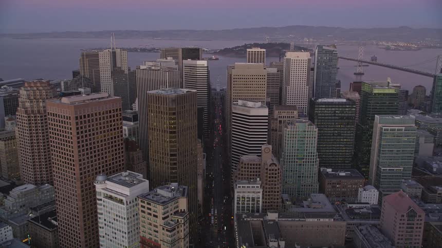 Cars drive past the skyscrapers in the city