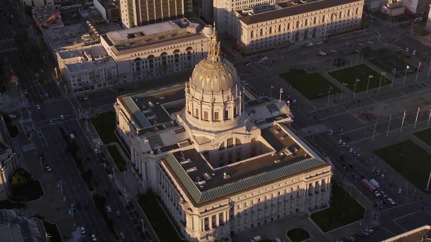 Traffic moves along the city streets passing a domed government building