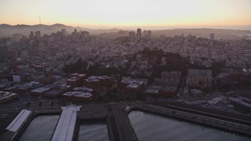 Aerial panorama of a seaside metropolis with docks on a purple and orange sky morning