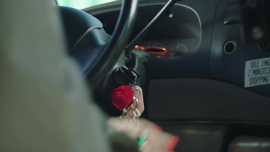 Closeup of a womans hand driving and then turning off the vehicle with the key