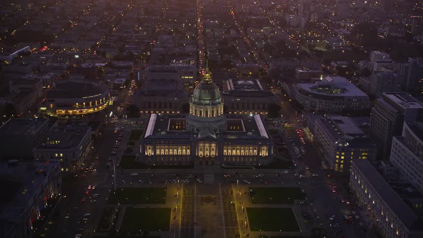 An aerial view of a big city with a domeshaped building in the center and it is at night and many city lights are on