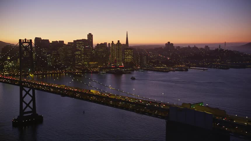 Aerial panorama of a bridge with vehicle traffic on the edge of a metropolis with skyscrapers and on a purple sky day