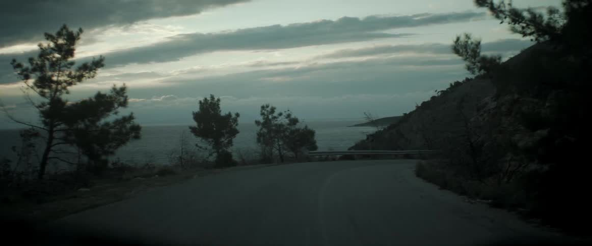 A vehicle travels on a coastal road