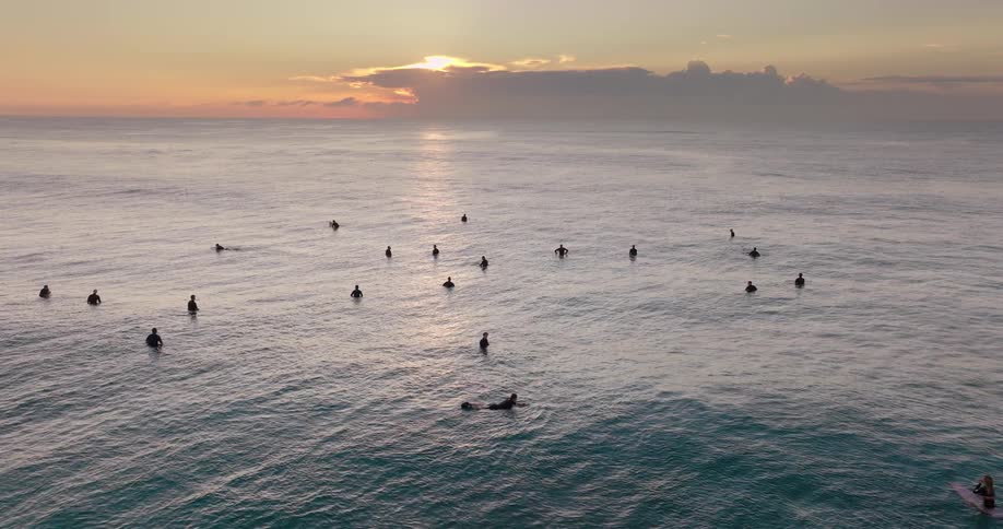 Surfers in the sea waiting for waves at dawn