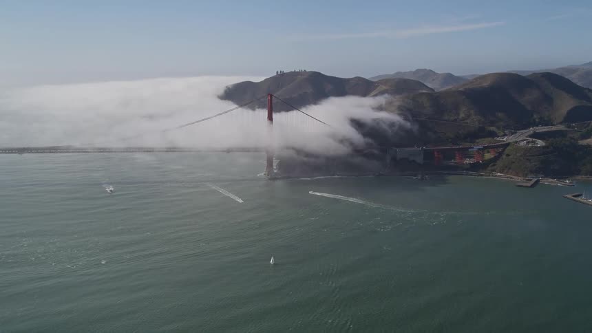 The golden gate bridge in san francisco is visible above a layer of fog