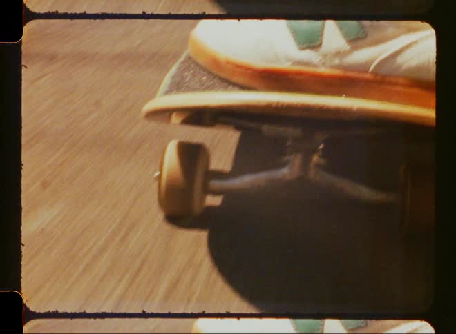 Feet of a person skateboarding on the asphalt