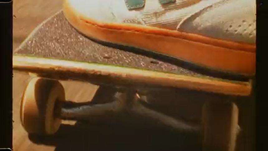 Foot of a person riding a skateboard on an asphalt