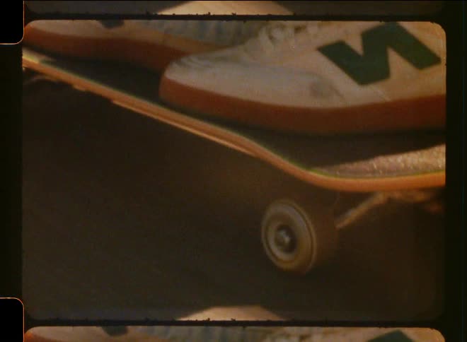 Close up of a person riding a skateboard caught on vintage film