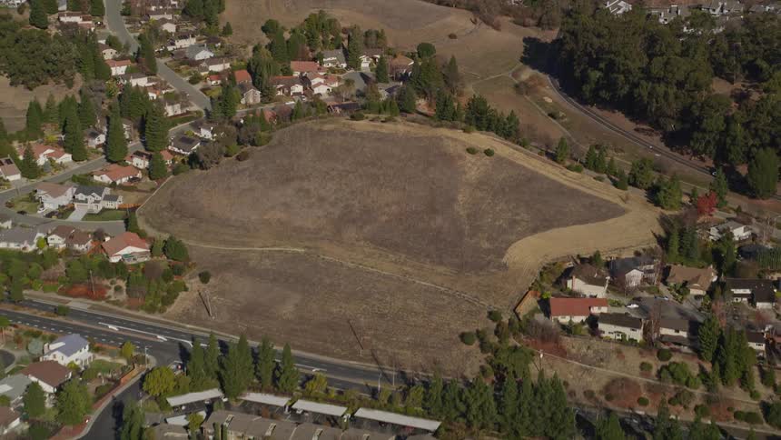 Aerial panorama of a suburb in a city built on hills and lined with trees