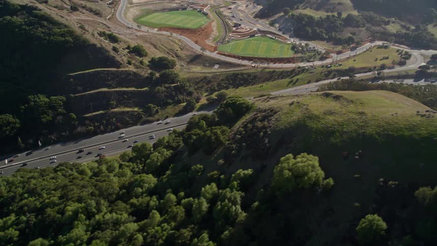 Aerial scenery of a highway with vehicle traffic and surrounding mountains with vegetation